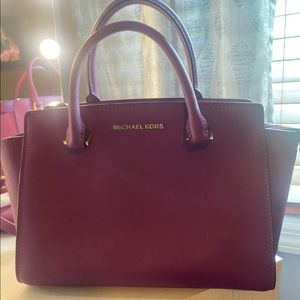 Plum purple Michael Kor handbag with crossbody strap.